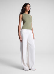 woman wearing green tank top and white pants