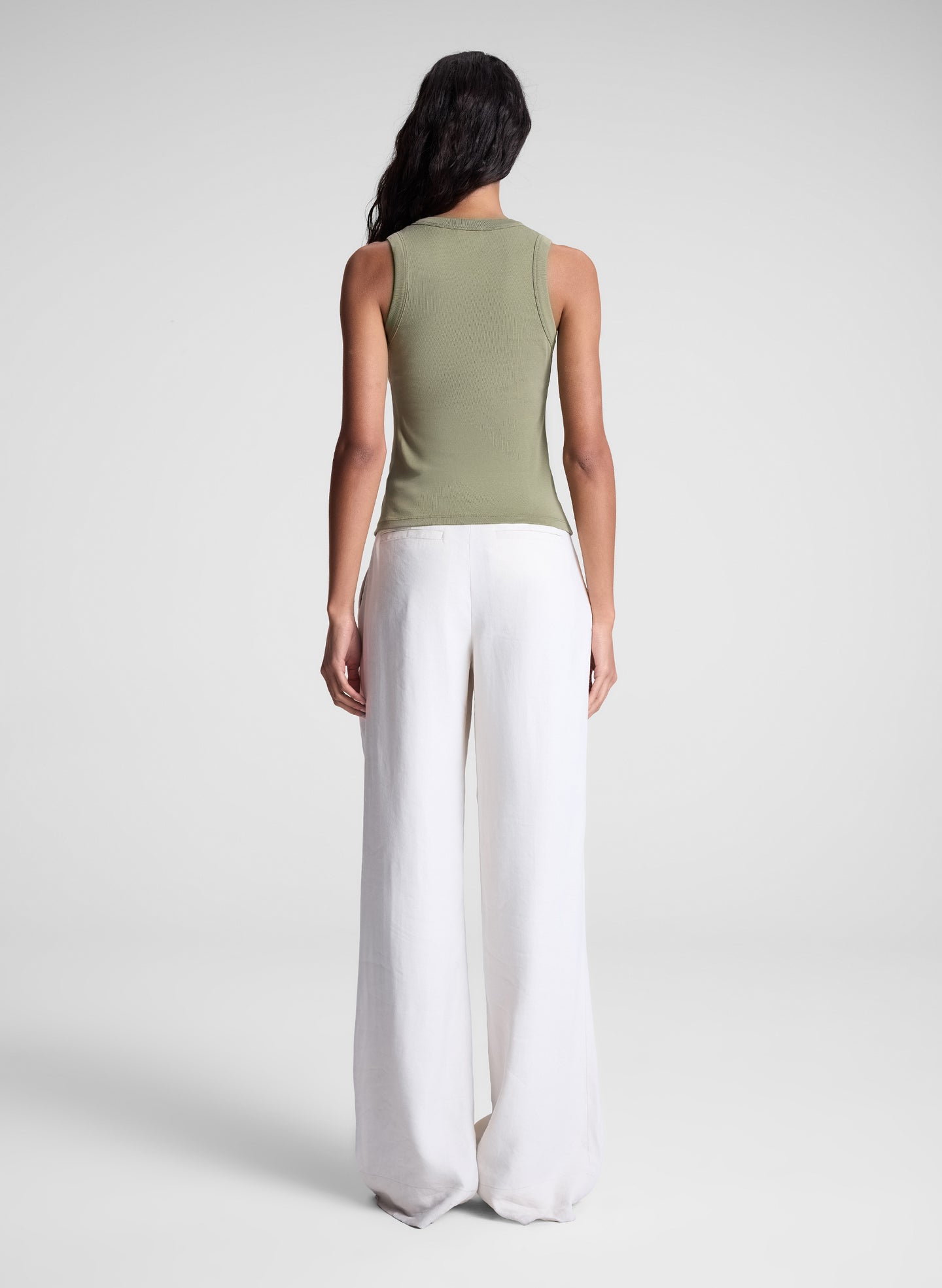 woman wearing green tank top and white pants