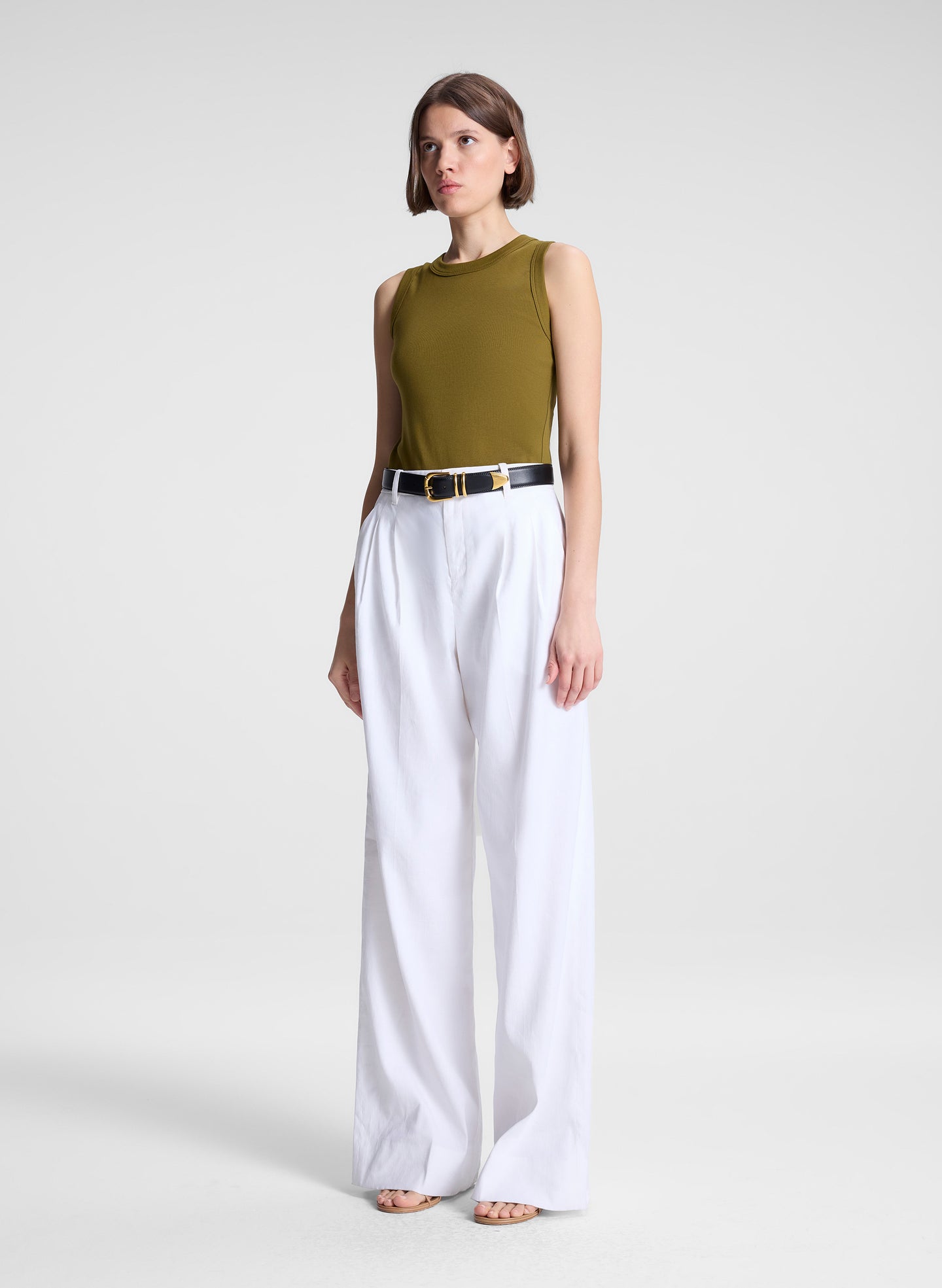 woman wearing white pants and green tank top