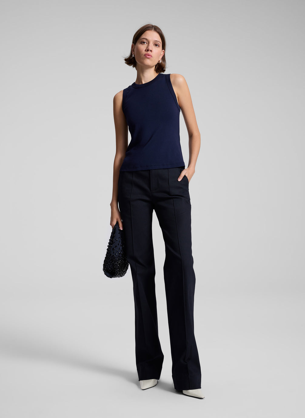 woman wearing navy blue tank top and black pants