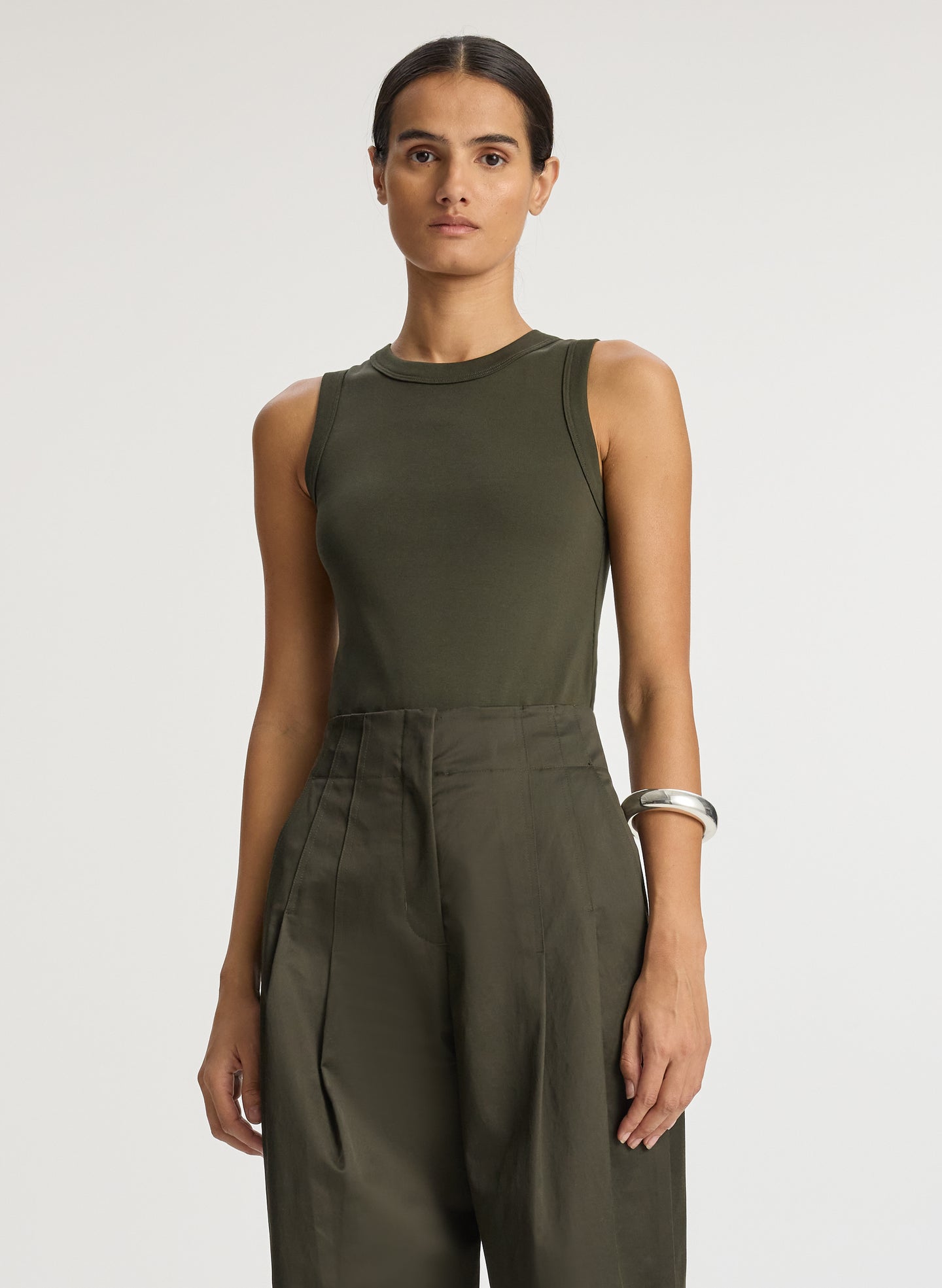 detail view of woman wearing olive green tank top and olive green wide leg sateen pants
