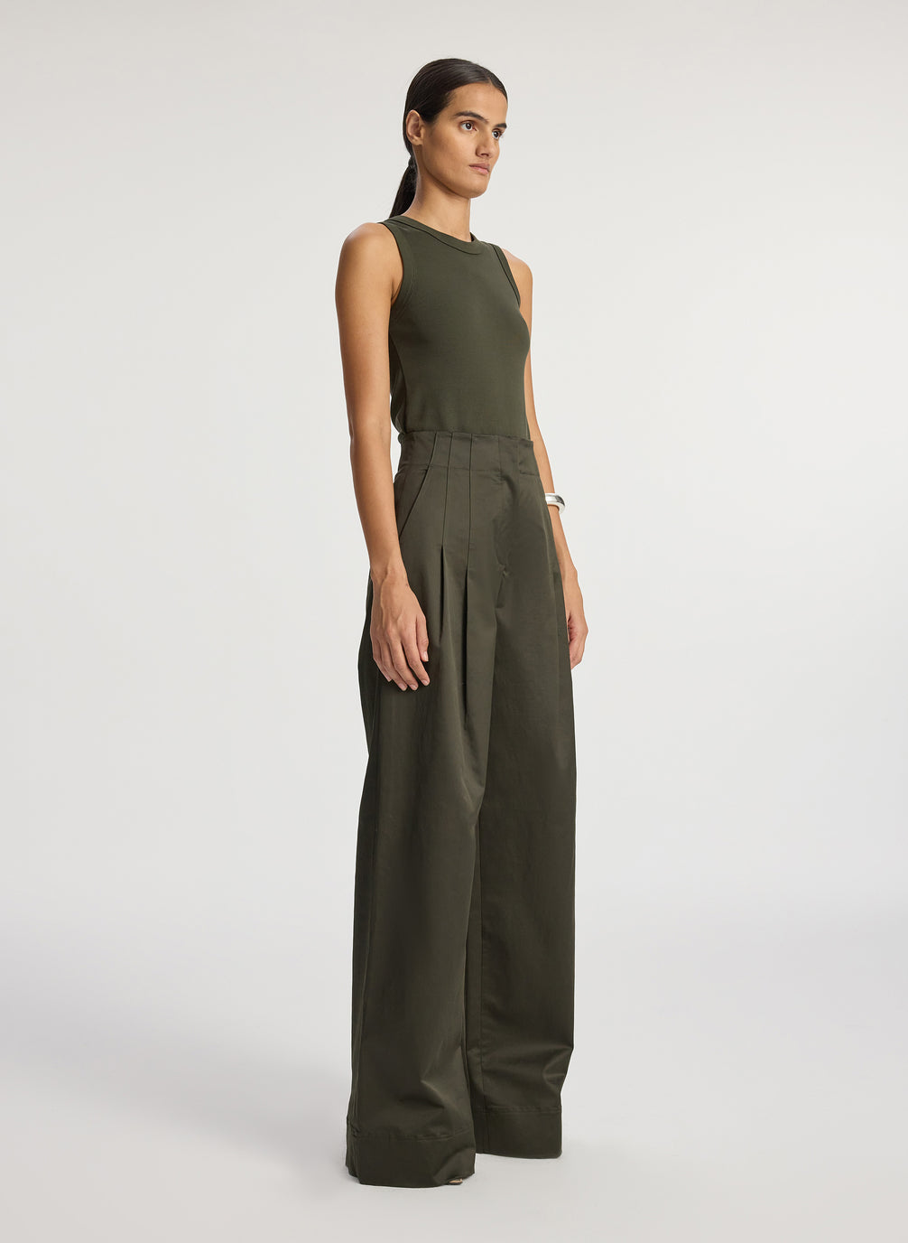 side view of woman wearing olive green tank top and olive green wide leg sateen pants