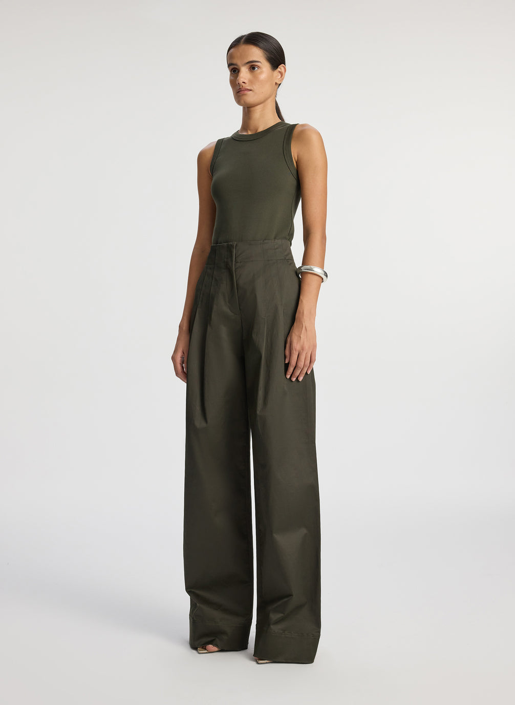 side view of woman wearing olive green tank top and olive green wide leg sateen pants