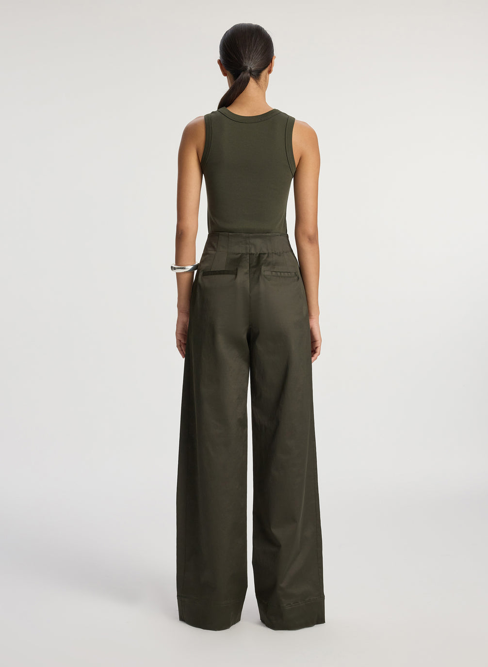 back view of woman wearing olive green tank top and olive green wide leg sateen pants