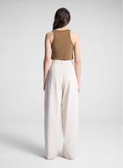 woman wearing brown cropped tank and white pants