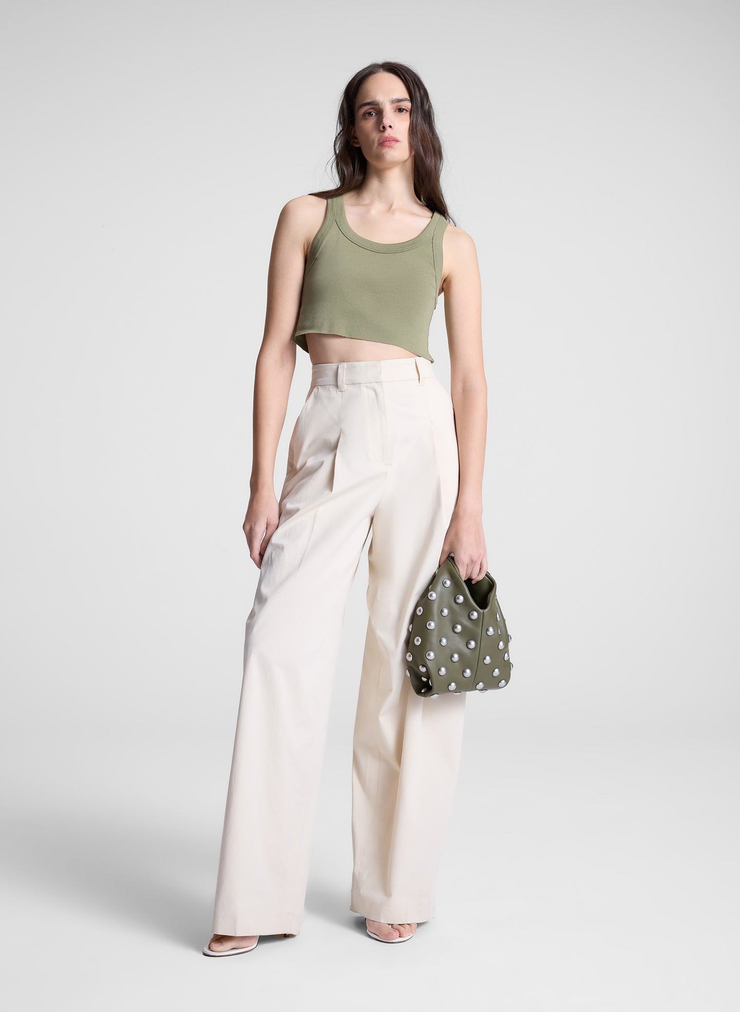 woman wearing green cropped tank and white pants