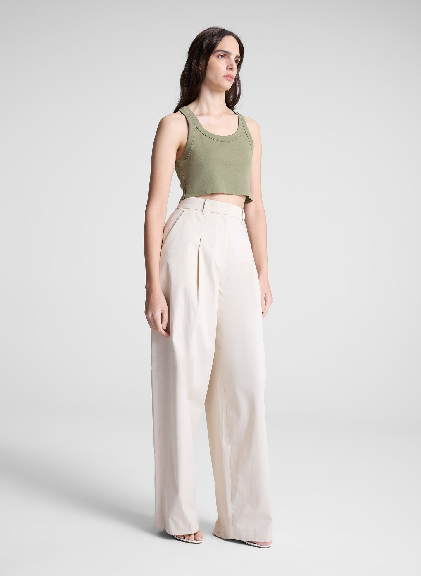 woman wearing green cropped tank and white pants