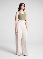 woman wearing green cropped tank and white pants