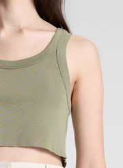 woman wearing green cropped tank and white pants