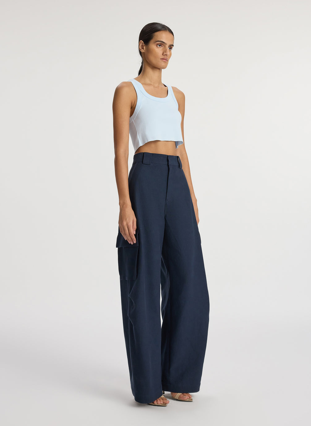 side view of woman wearing light blue cropped rib tank top and navy blue cargo pants