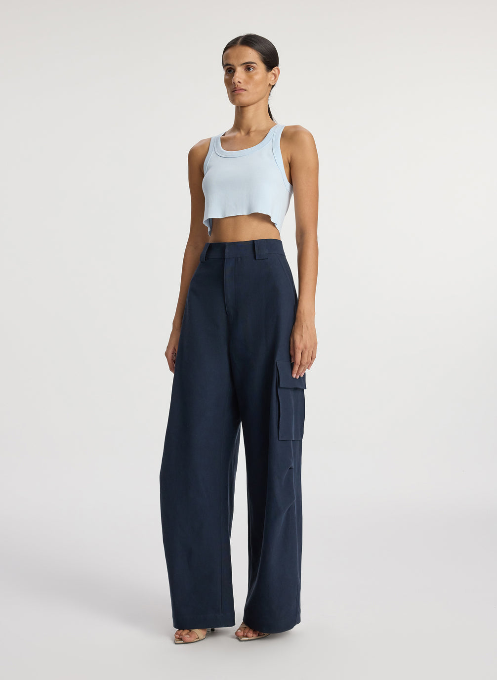 side view of woman wearing light blue cropped rib tank top and navy blue cargo pants