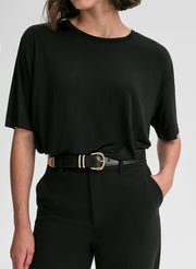 Person wearing a black outfit with a belt on a white background