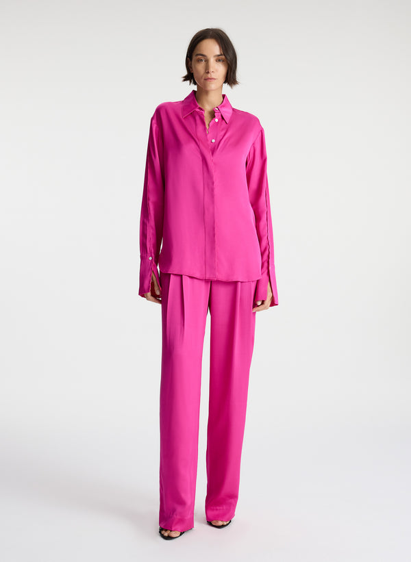 front view of woman wearing bright pink scalloped detailed long sleeve satin shirt and bright pink pants