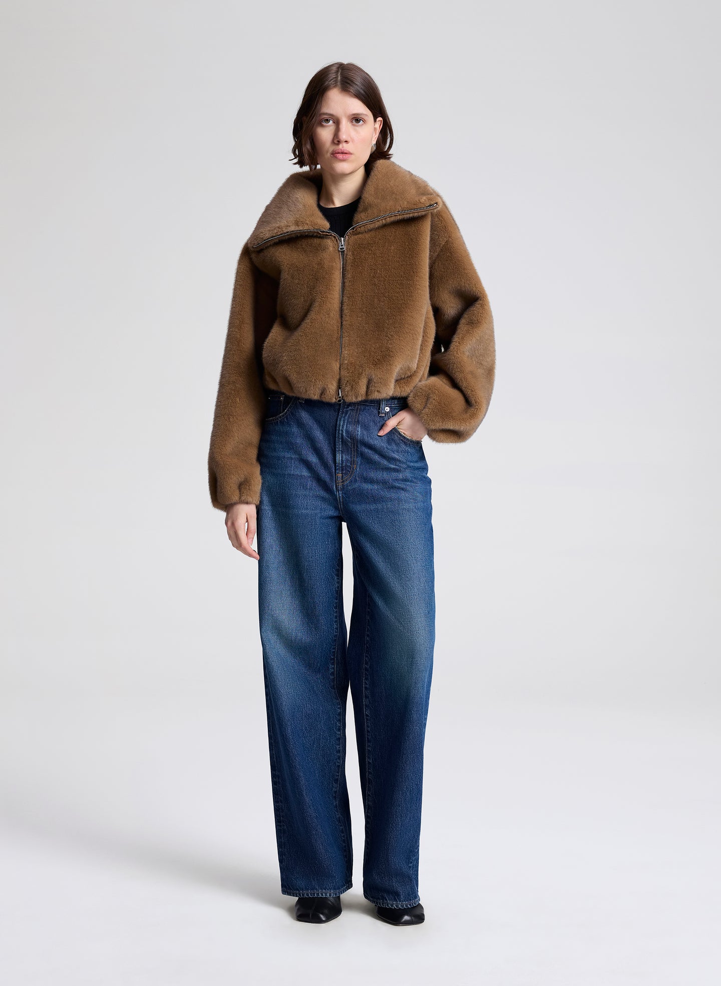 woman wearing a brown faux fur jacket and jeans