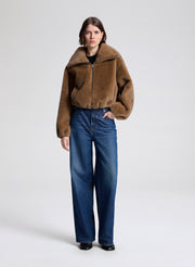 woman wearing a brown faux fur jacket and jeans