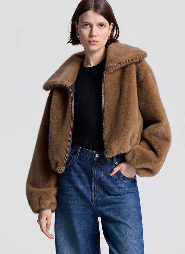 woman wearing brown faux fur jacket and jeans