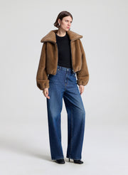woman wearing a brown faux fur jacket and jeans