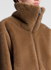 woman wearing a brown faux fur jacket and jeans