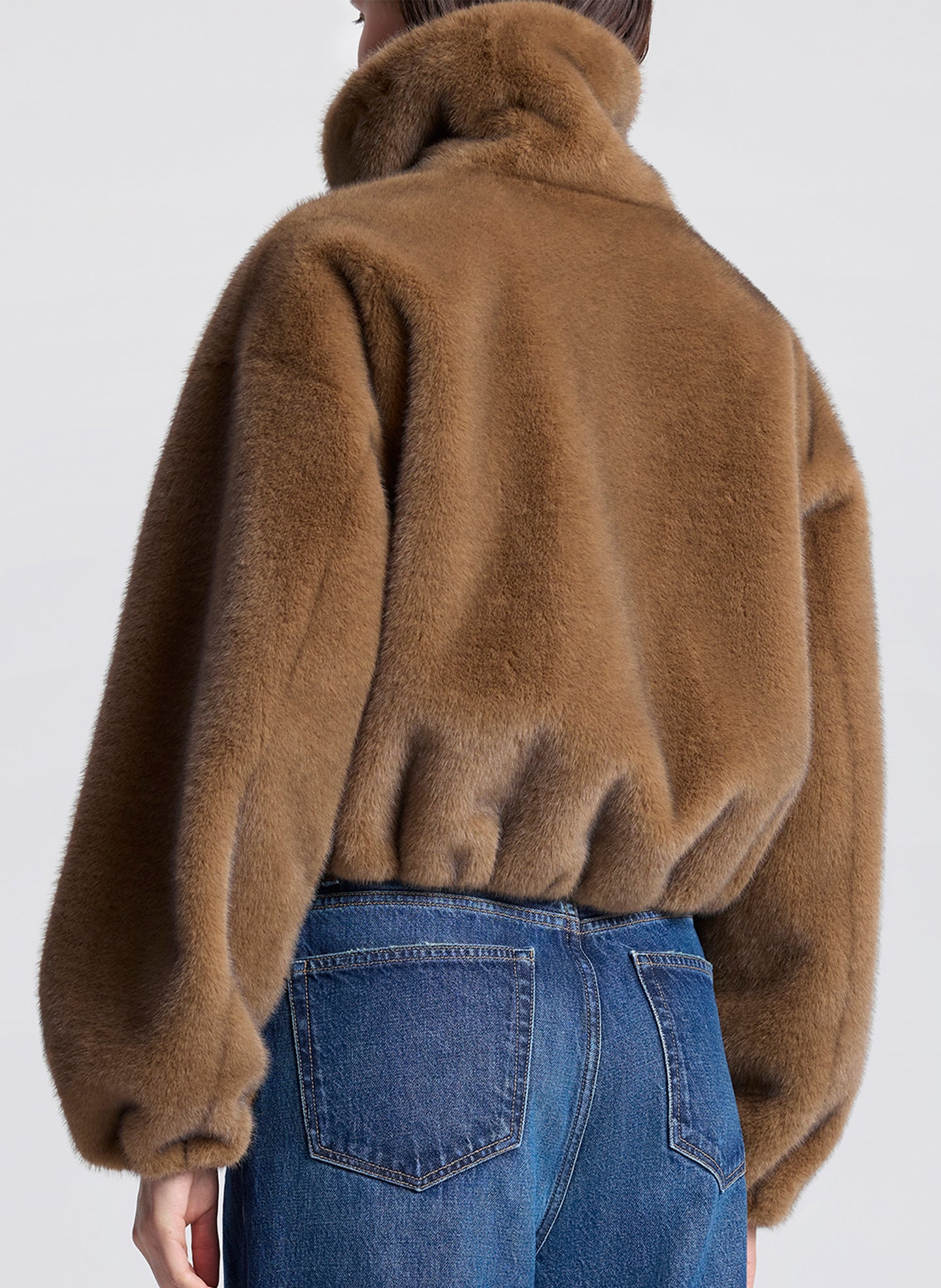 woman wearing a brown faux fur jacket and jeans