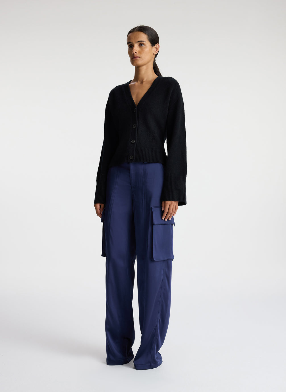 side view of woman wearing black cardigan with navy blue cargo pants