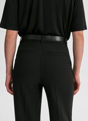 Person wearing a black shirt and black pants on a white background