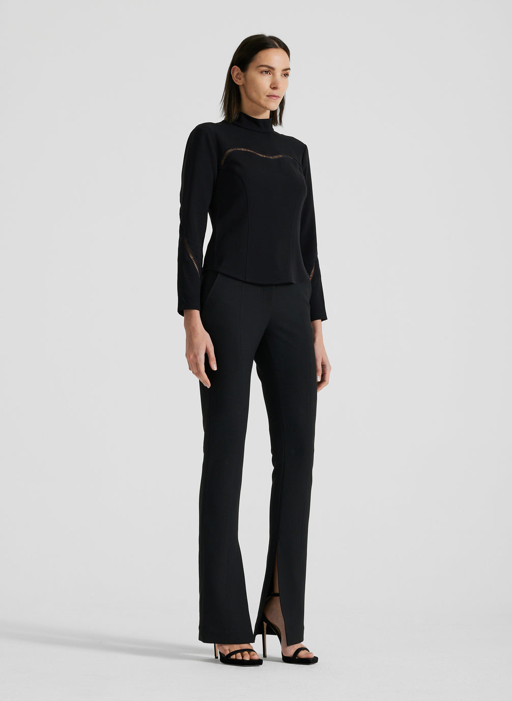 side view of woman wearing black long sleeve shirt and black pants