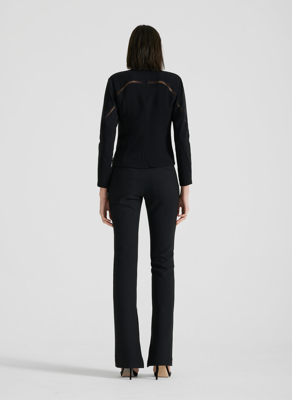 back view of woman wearing black long sleeve shirt and black pants