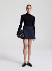 woman holding black studded handbag