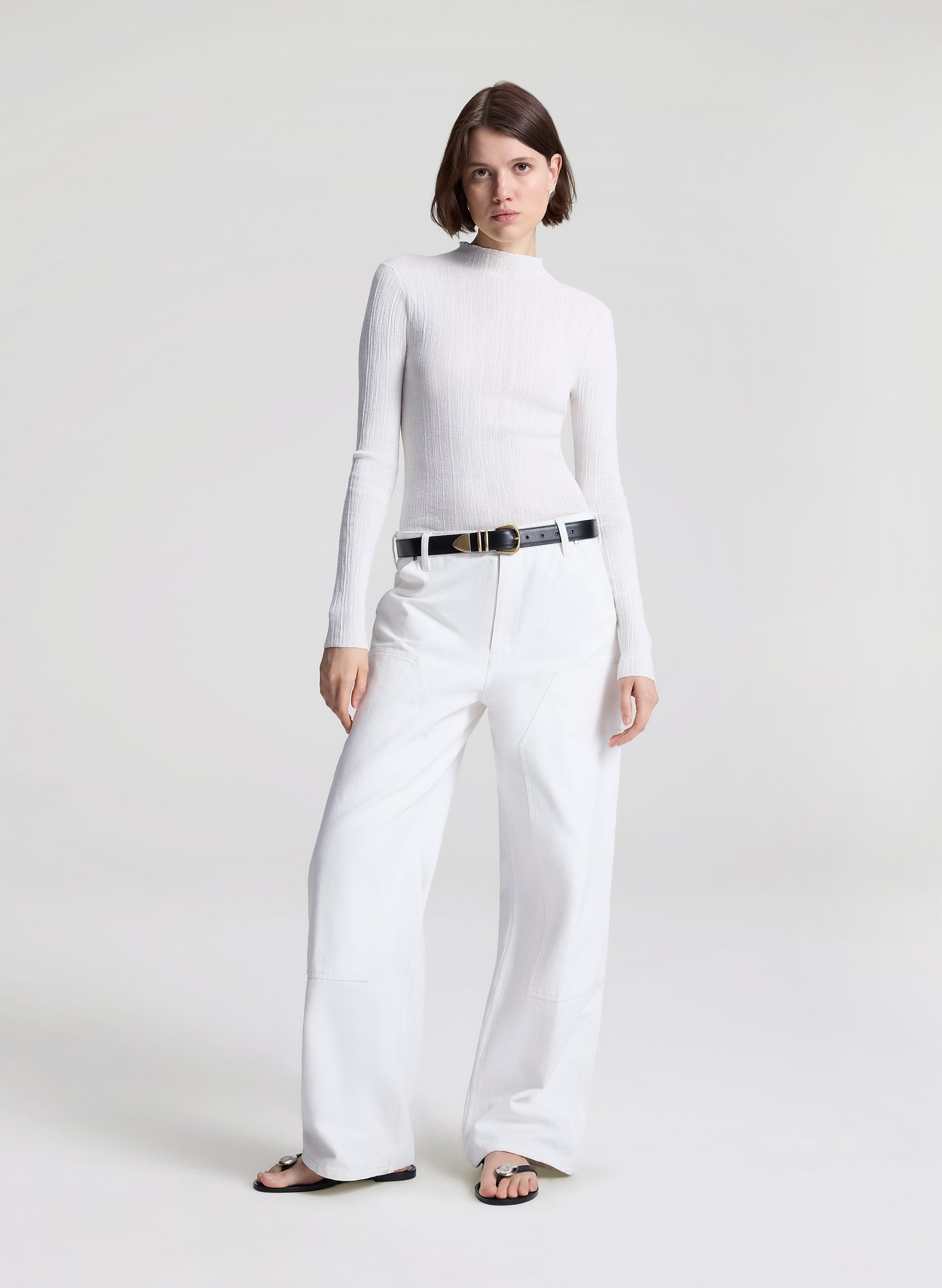 woman wearing white fine gauge voile knit top and white denim jeans