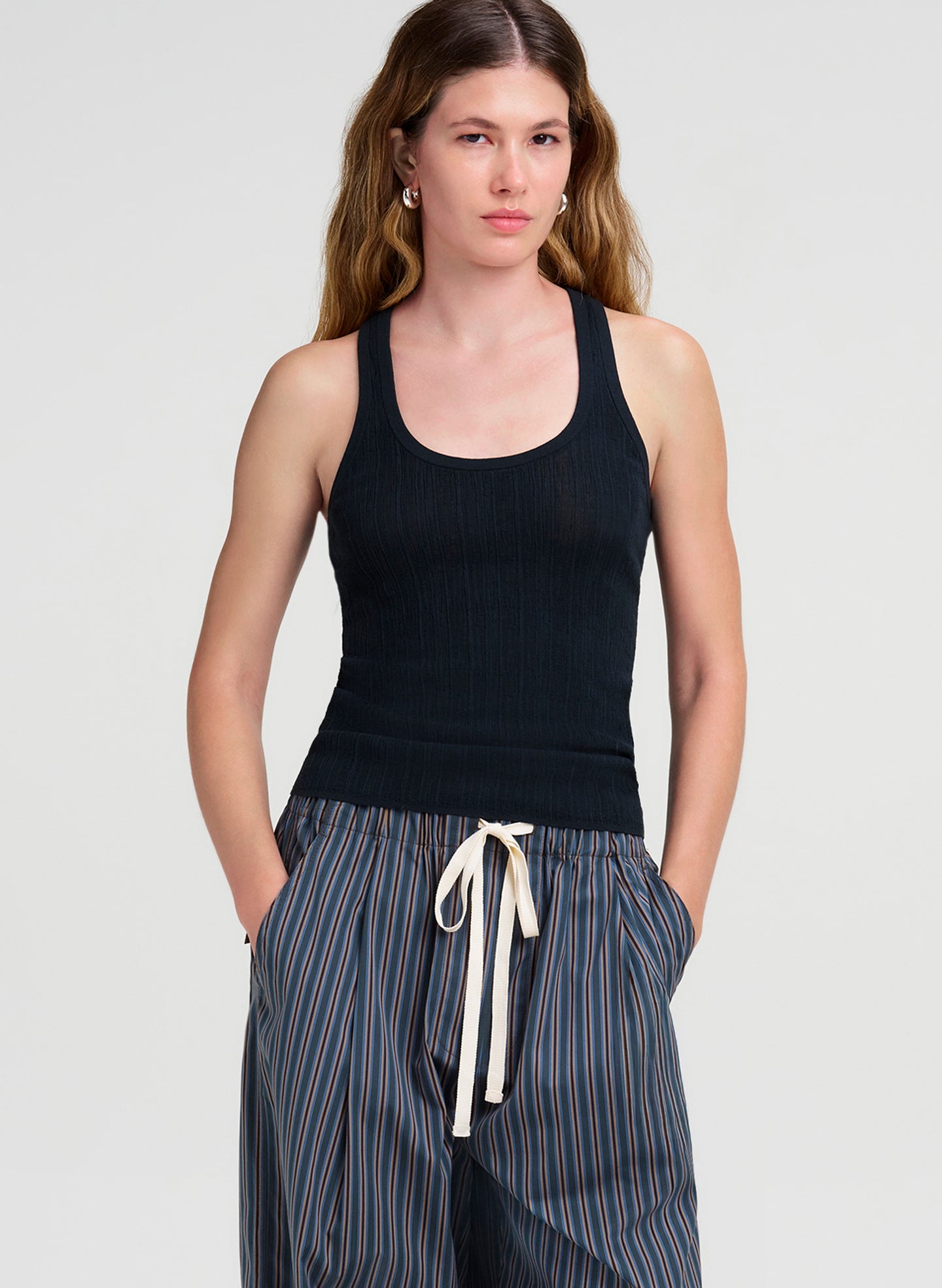 woman wearing dark green tank top and striped pants