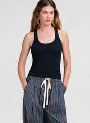 woman wearing dark green tank top and striped pants