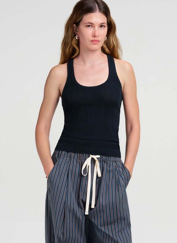 woman wearing dark green tank top and striped pants