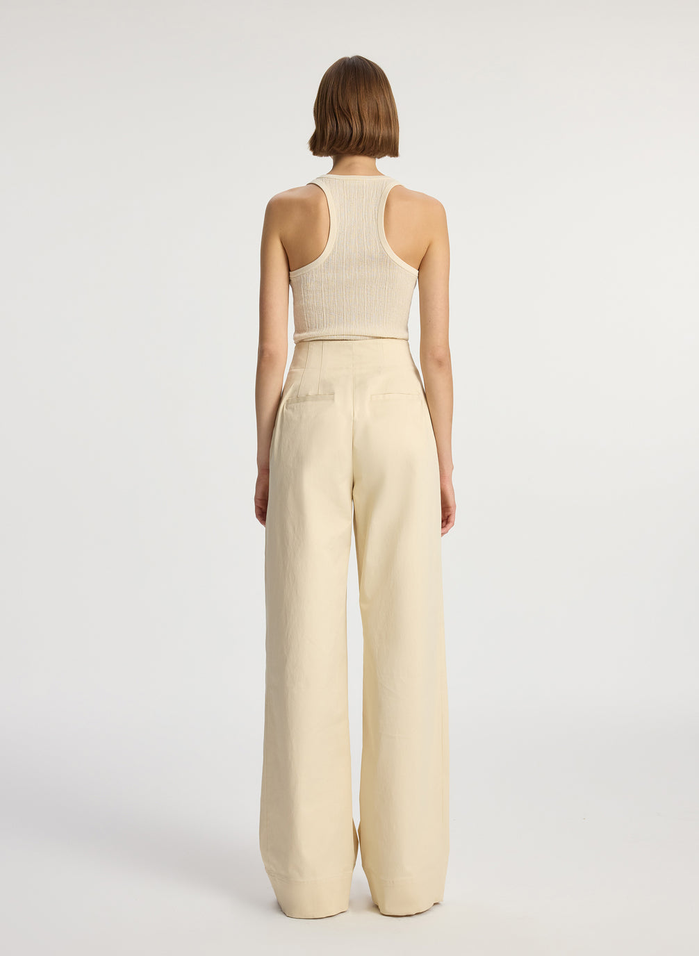 back  view of woman wearing cream tank top and beige sateen wide leg pants
