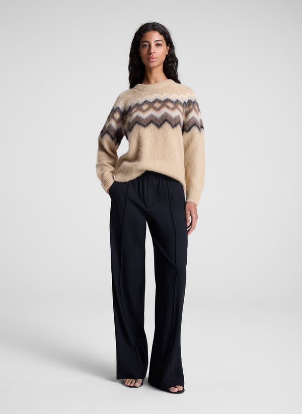 woman wearing tan fairisle sweater and black pants