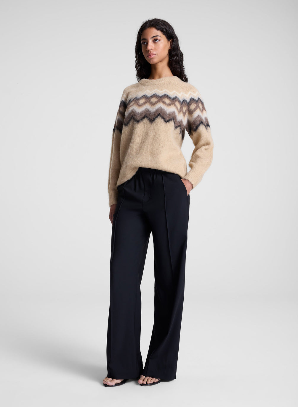 woman wearing tan fairisle sweater and black pants