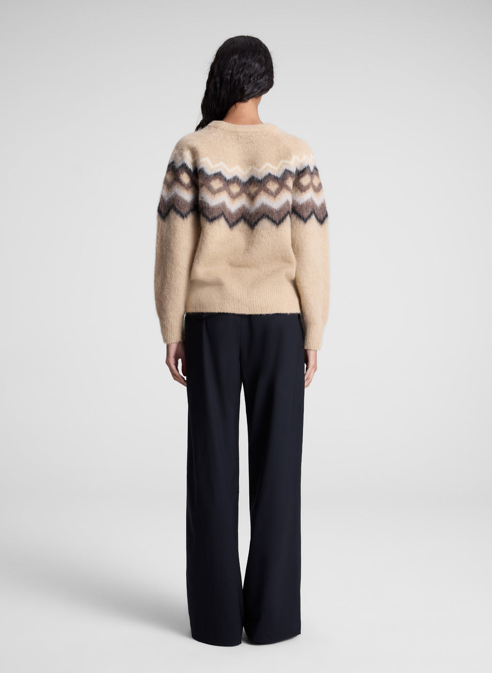 woman wearing tan fairisle sweater and black pants