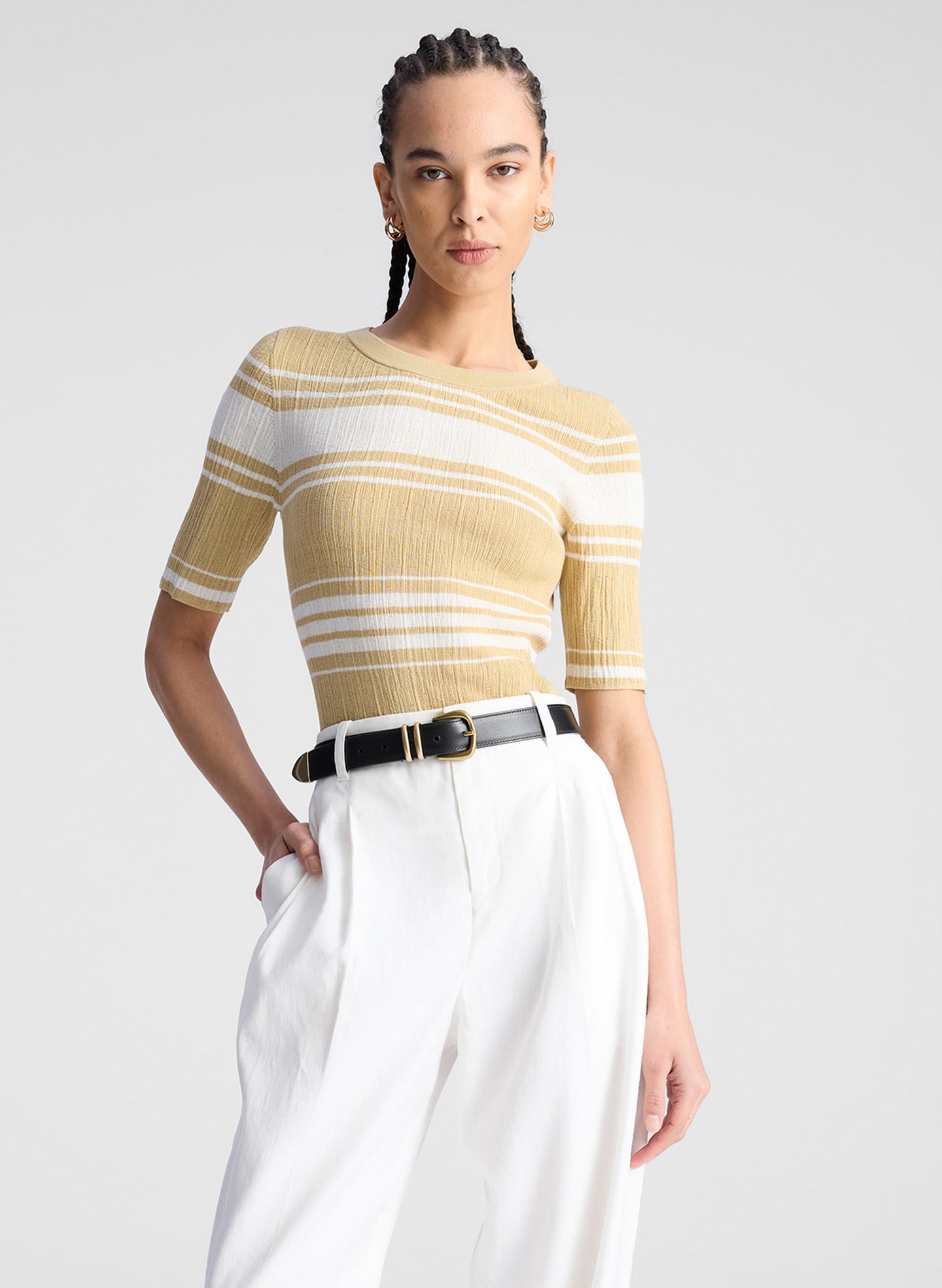 woman wearing tan and white striped top with white pants