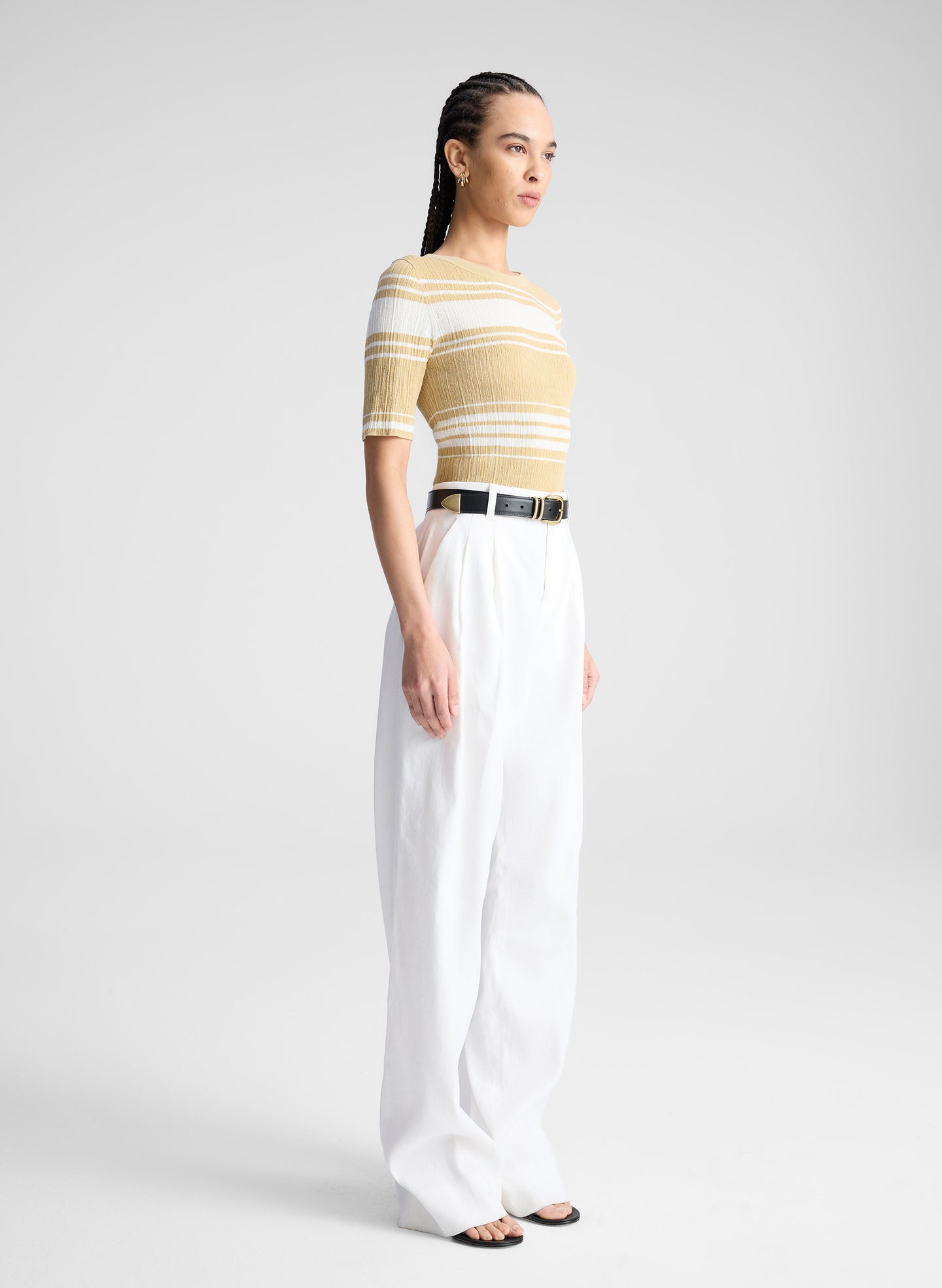 woman wearing tan and white striped top with white pants