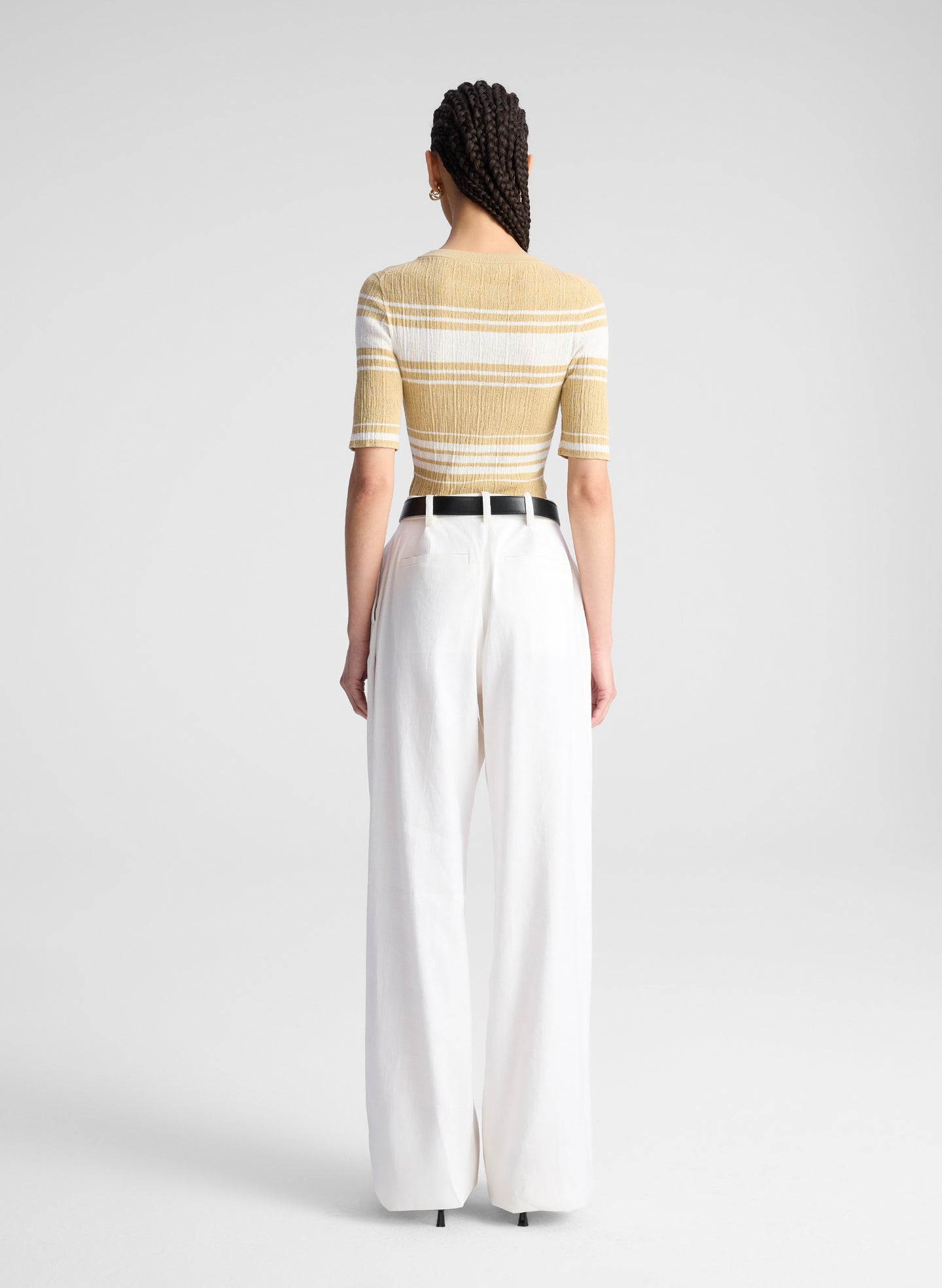 woman wearing tan and white striped top with white pants