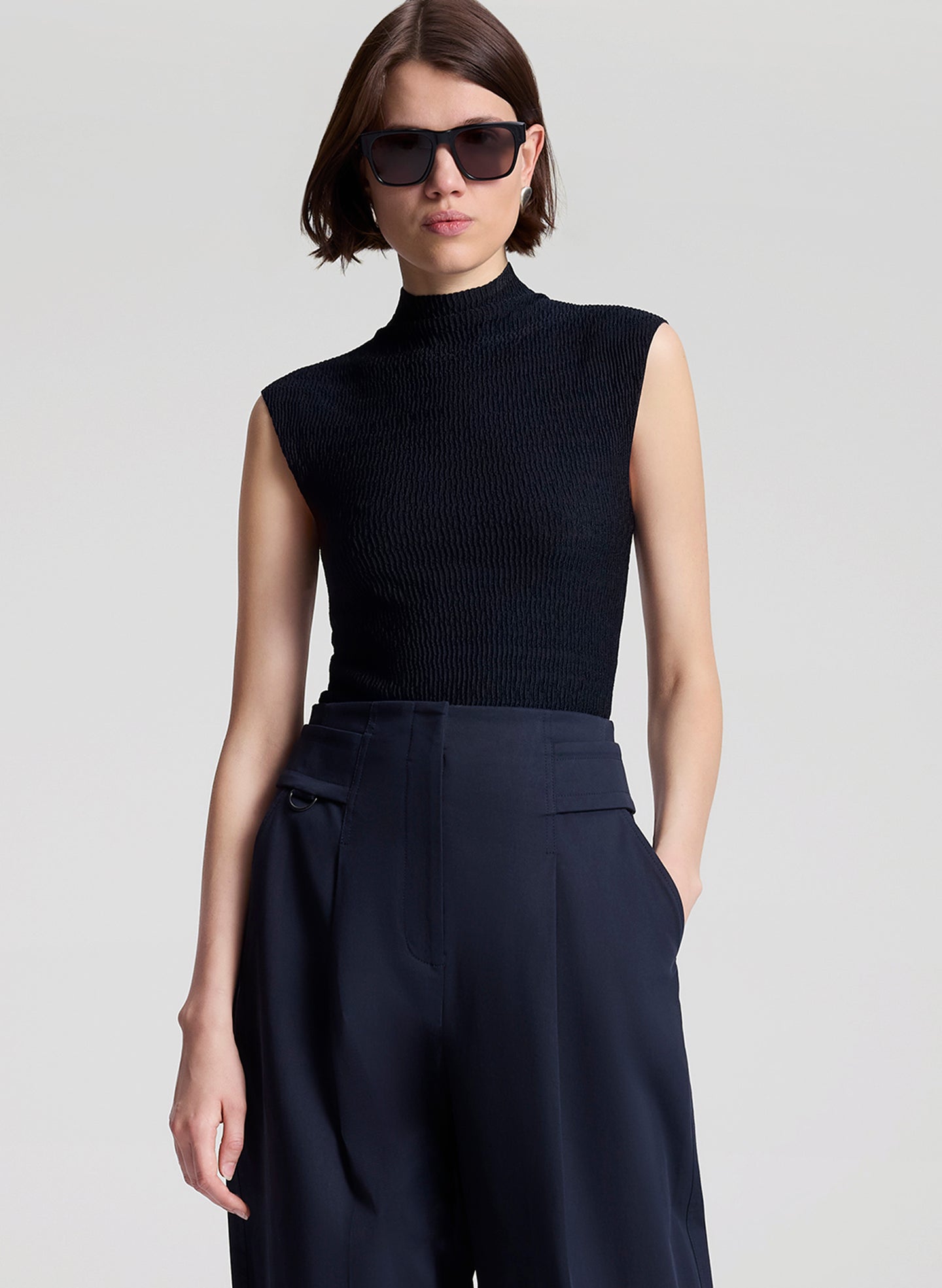 woman wearing navy blue sleeveless knit top and navy blue pants