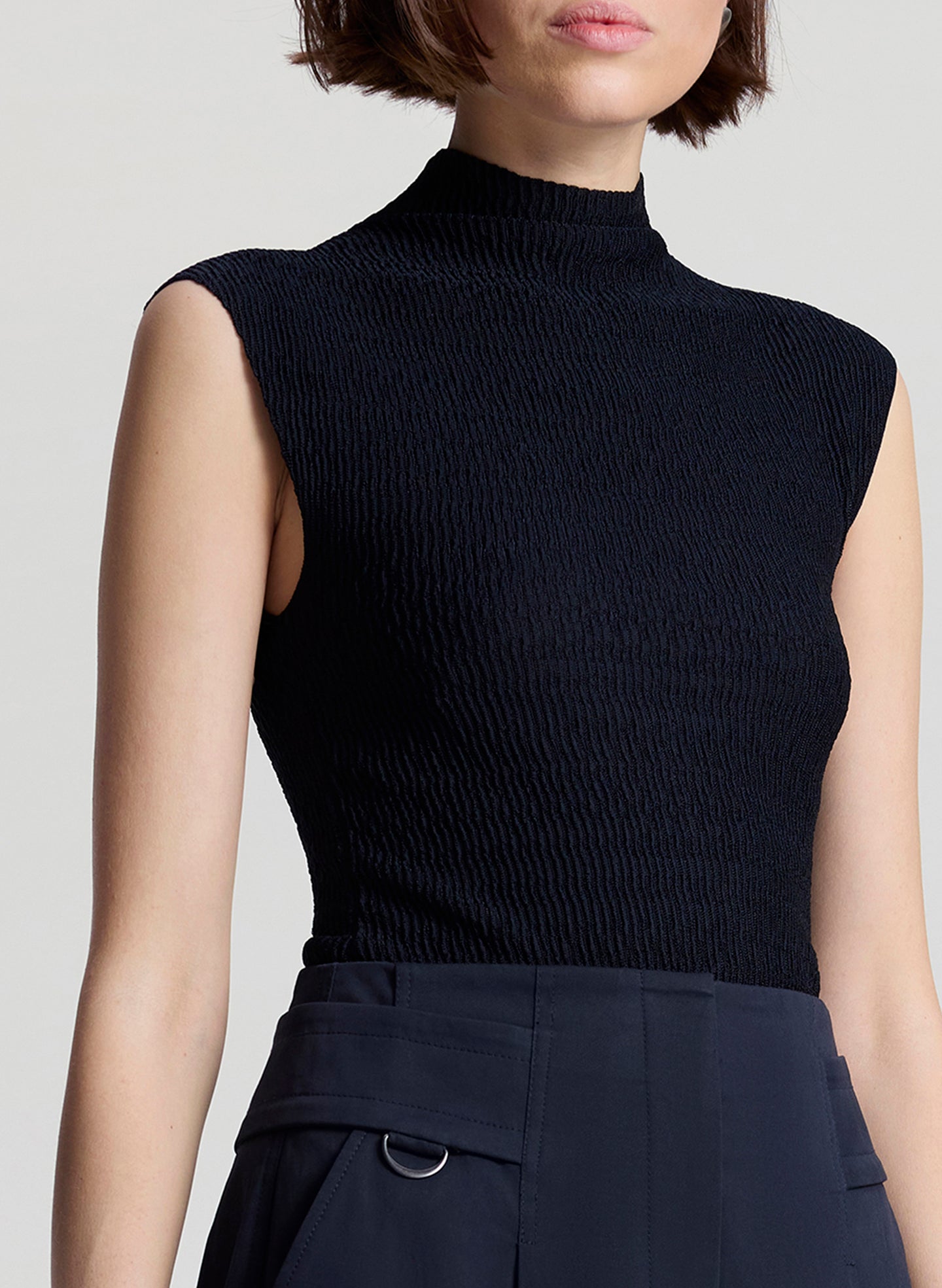 woman wearing navy blue sleeveless knit top and navy blue pants