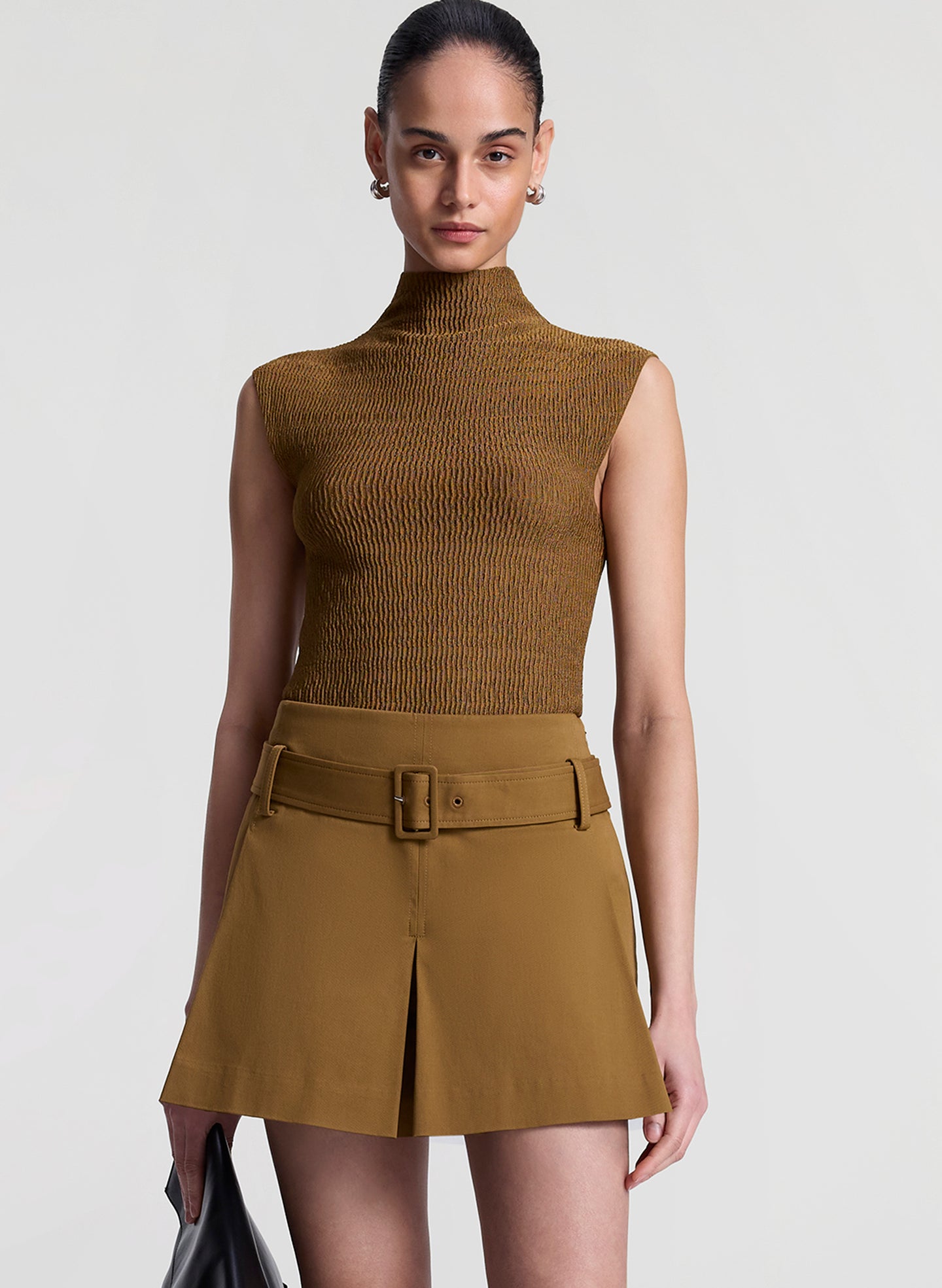woman wearing brown sleeveless mock neck knit top and brown skort