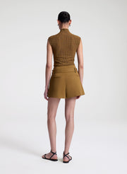 woman wearing brown sleeveless mock neck knit top and brown skort
