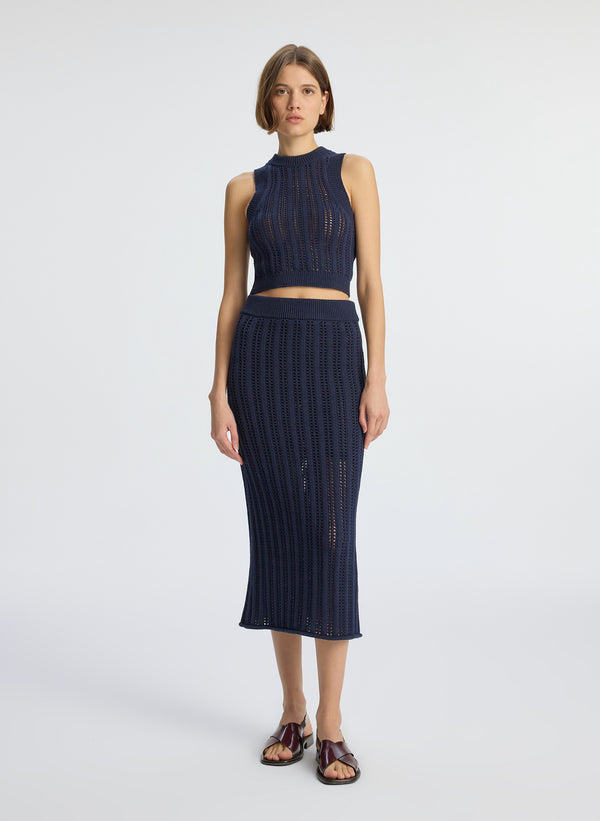 Front view of woman wearing navy blue woven tank top and matching midi skirt