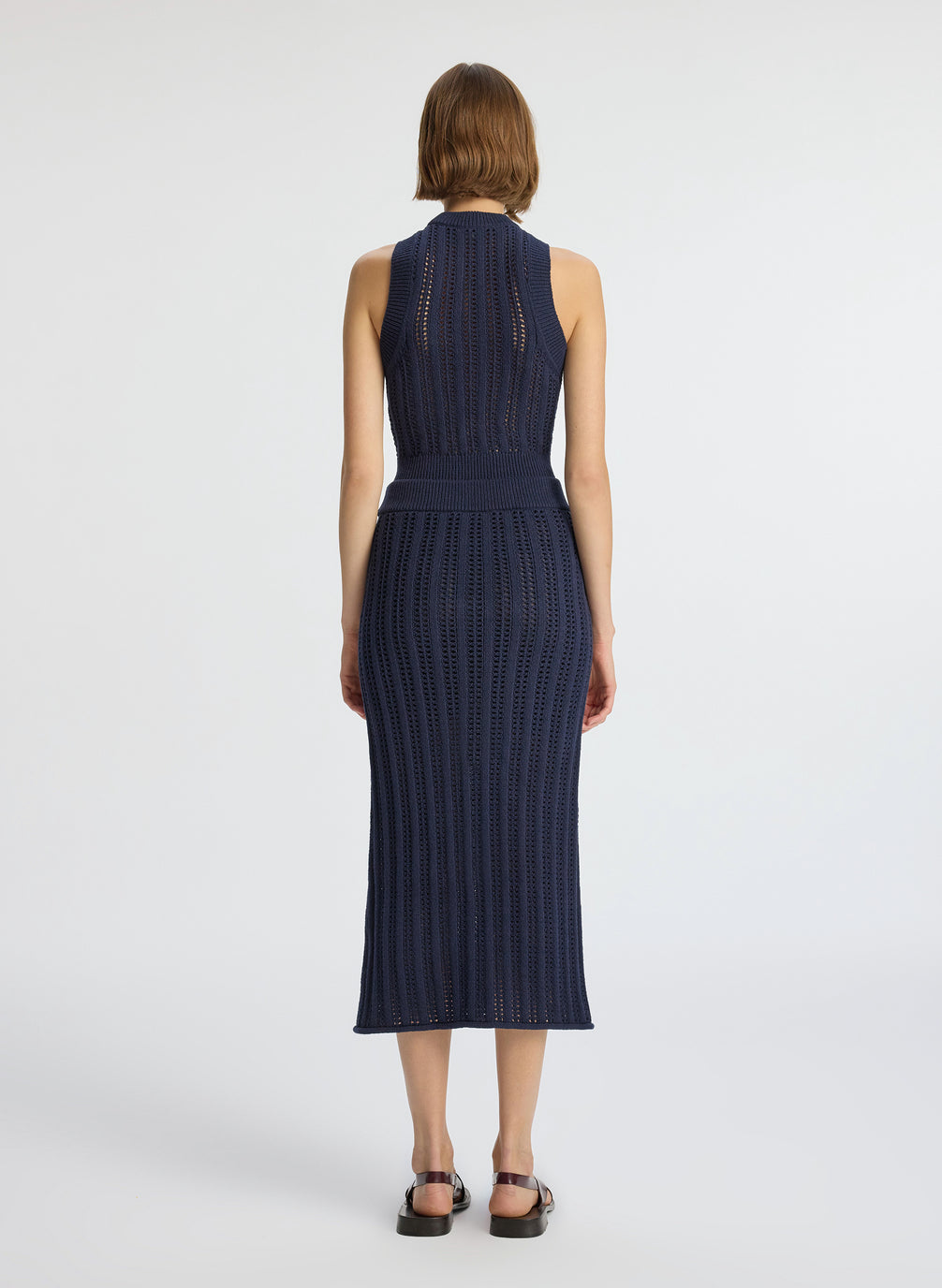 back  view of woman wearing navy blue woven tank top and matching midi skirt