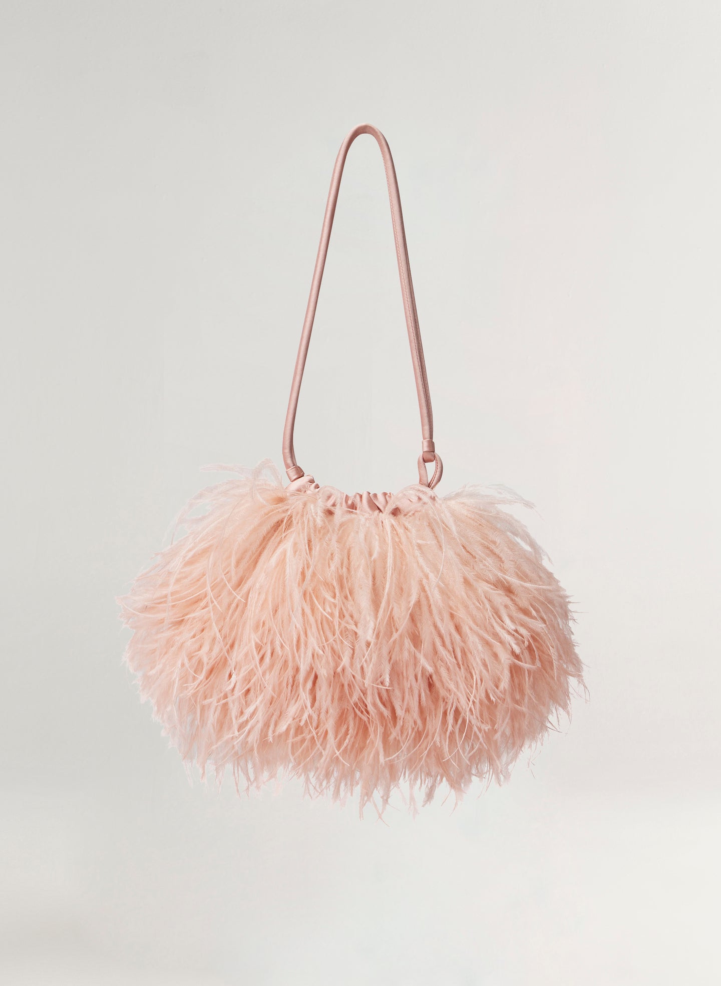 Pink feathered handbag on a light gray background