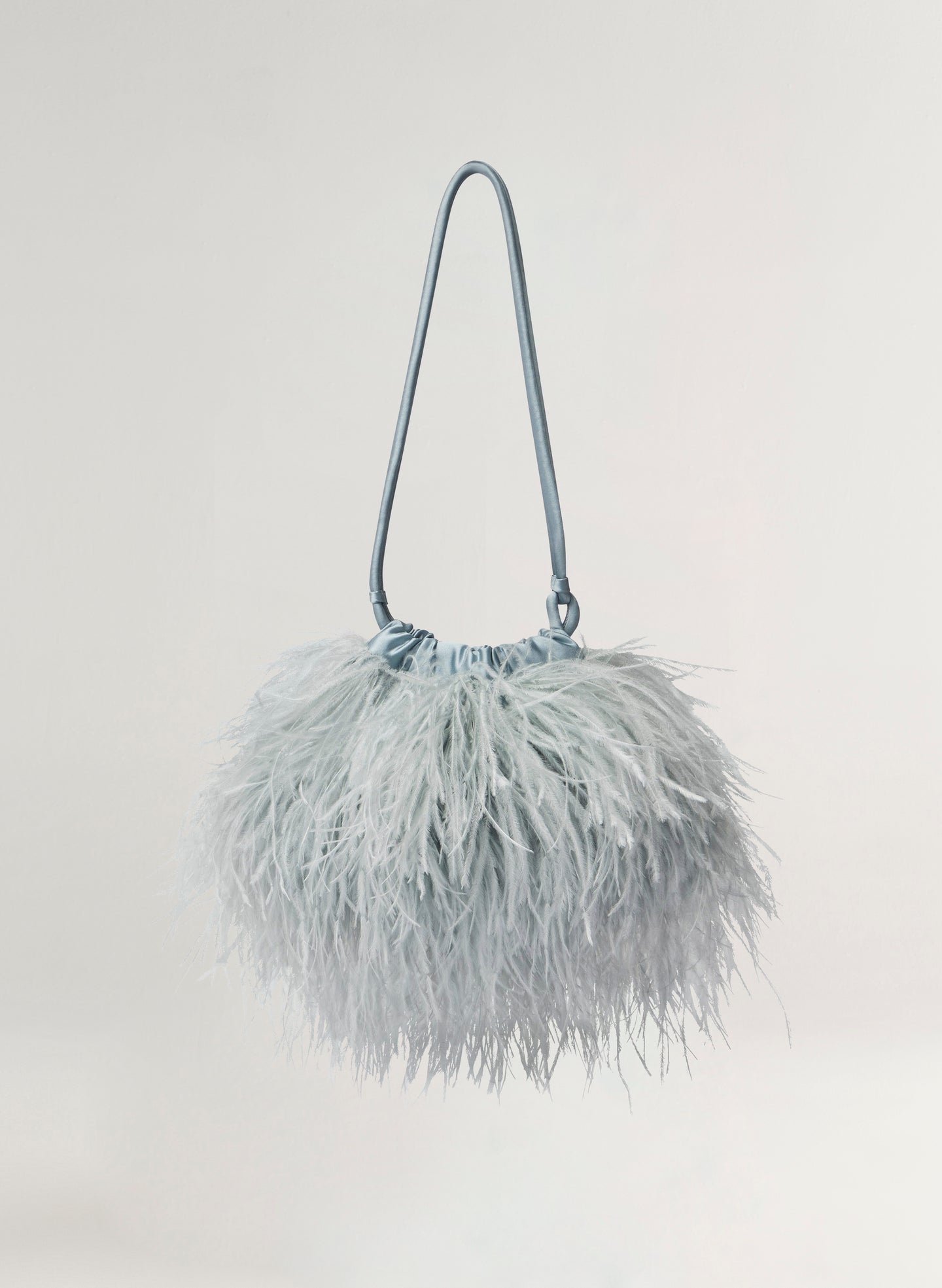 blue feathered handbag on a light gray background
