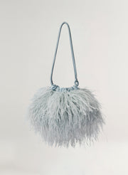 blue feathered handbag on a light gray background