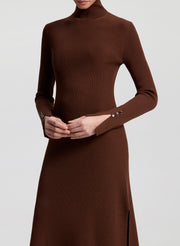 Woman wearing a brown dress holding a faux fur bag on a white background