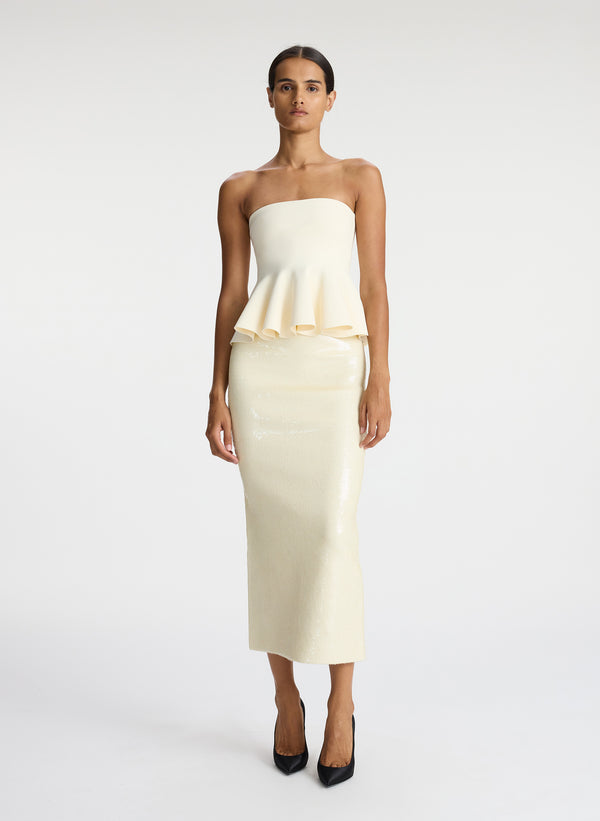 front view of woman wearing cream strapless peplum top and cream sequined midi skirt